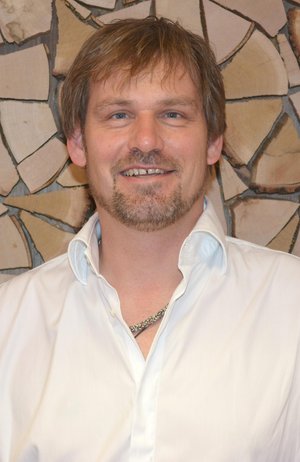 Geschäftsführer Reinhard Pichler vor einer Holzwand
