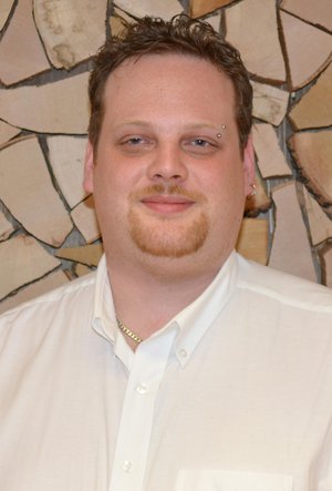 Technischer Support Florian Duffner vor einer Holzwand